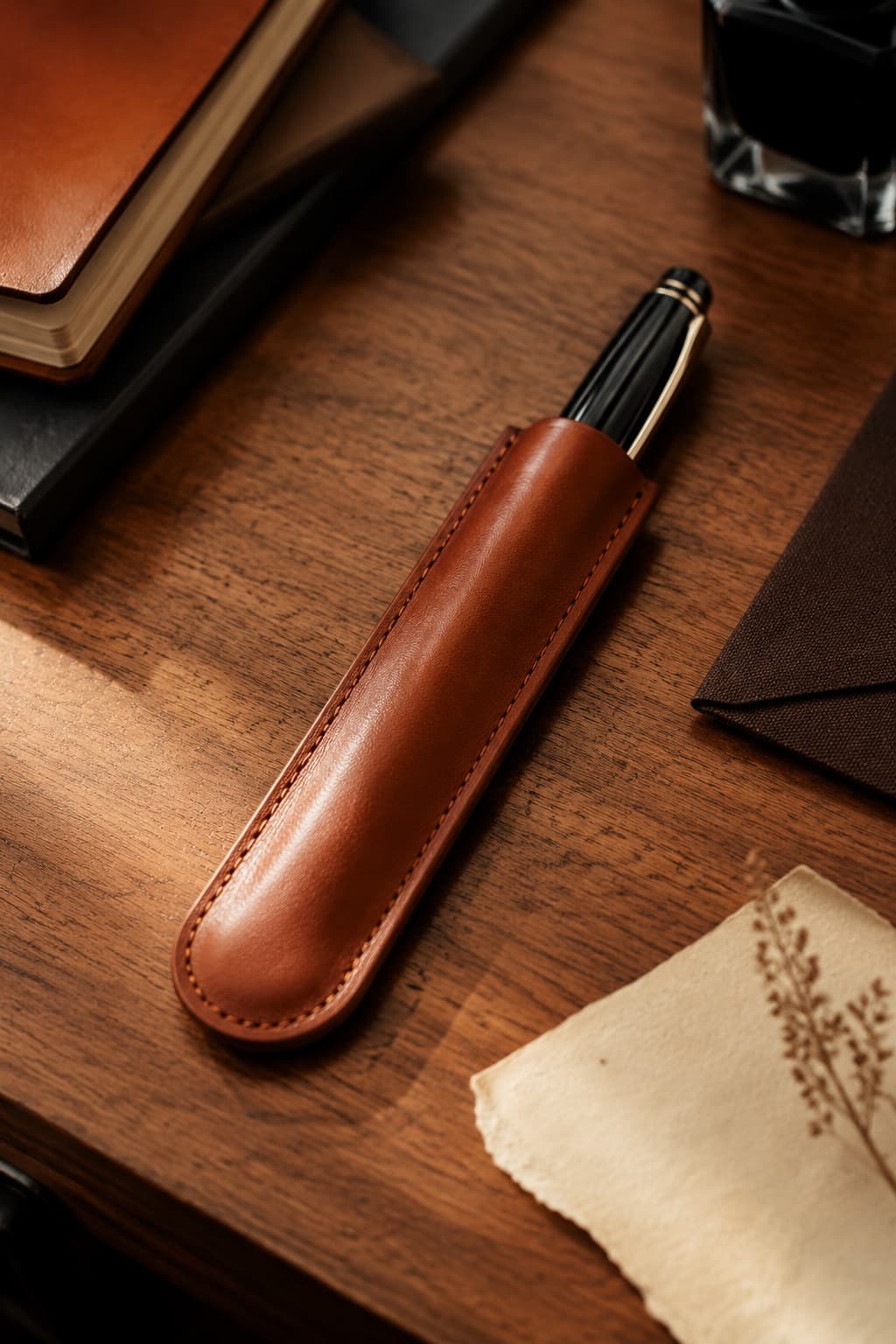 Cognac full-grain leather single-pen sleeve with a fountain pen slipping into it
